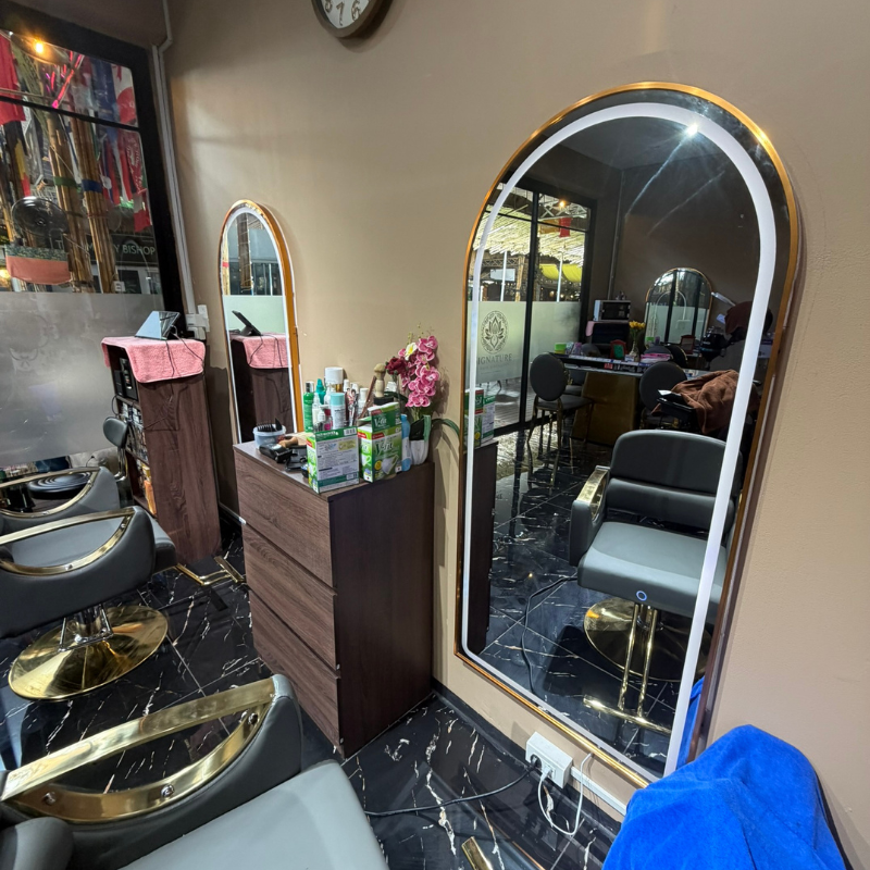 Salon interior with arched LED mirrors, styling chairs and marble floor